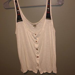 Cream tank top with strap accent patterns
